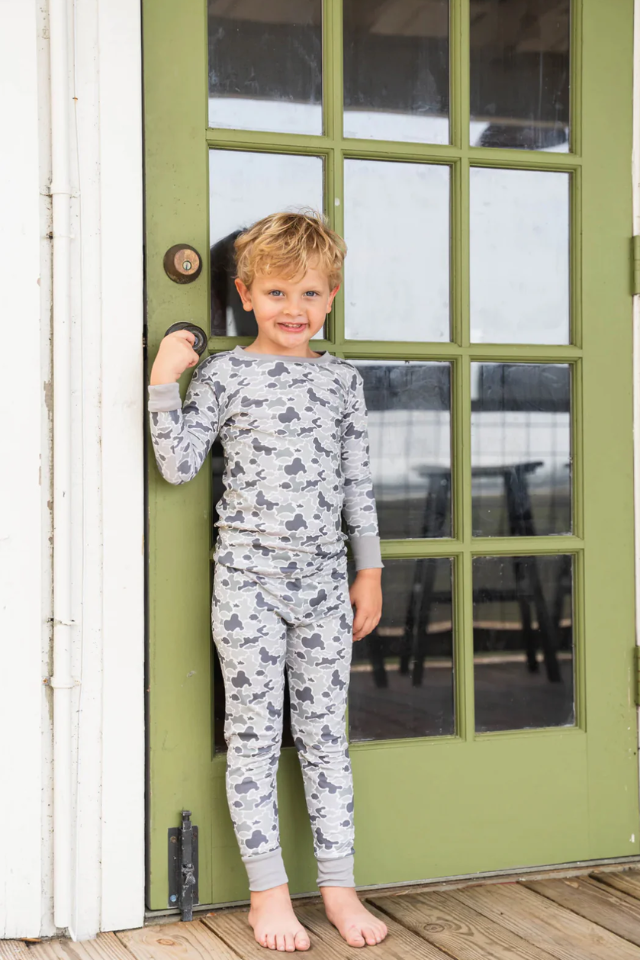 Child wearing a camouflage outfit standing in front of a green door. camo. boys, boys, camo, aouth, southern, pajamas,